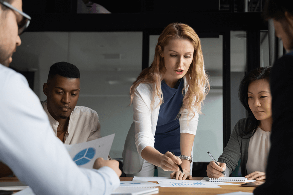 Concentrated young businesswoman explaining market research results in graphs